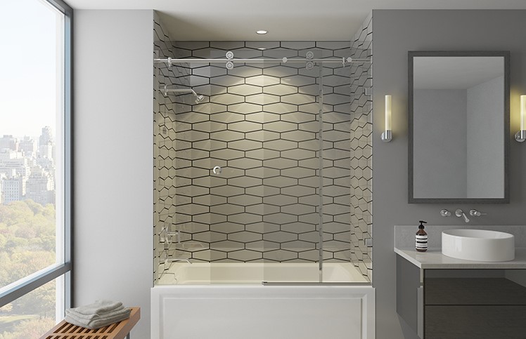 Photograph of frameless shower doors above a bath tub in a modern bathroom