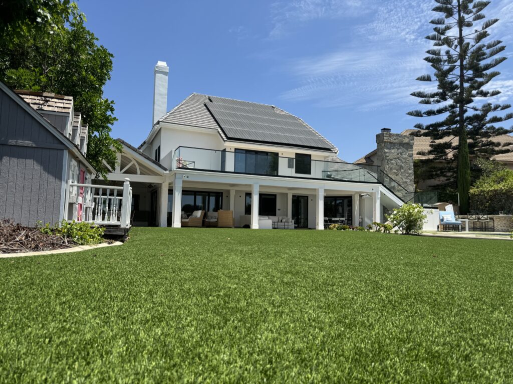 Photo of a large home in Orange County showing custom glass railings on an upstairs patio and an outdoor staircase